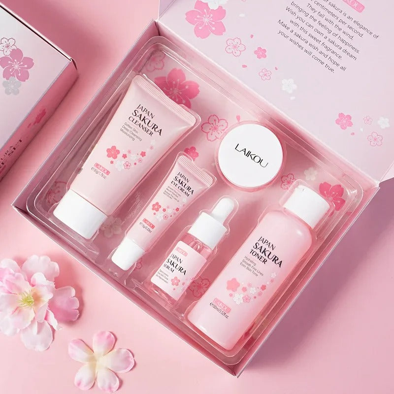 Cosmetic set with Sakura-themed products in a pink box on a matching background.